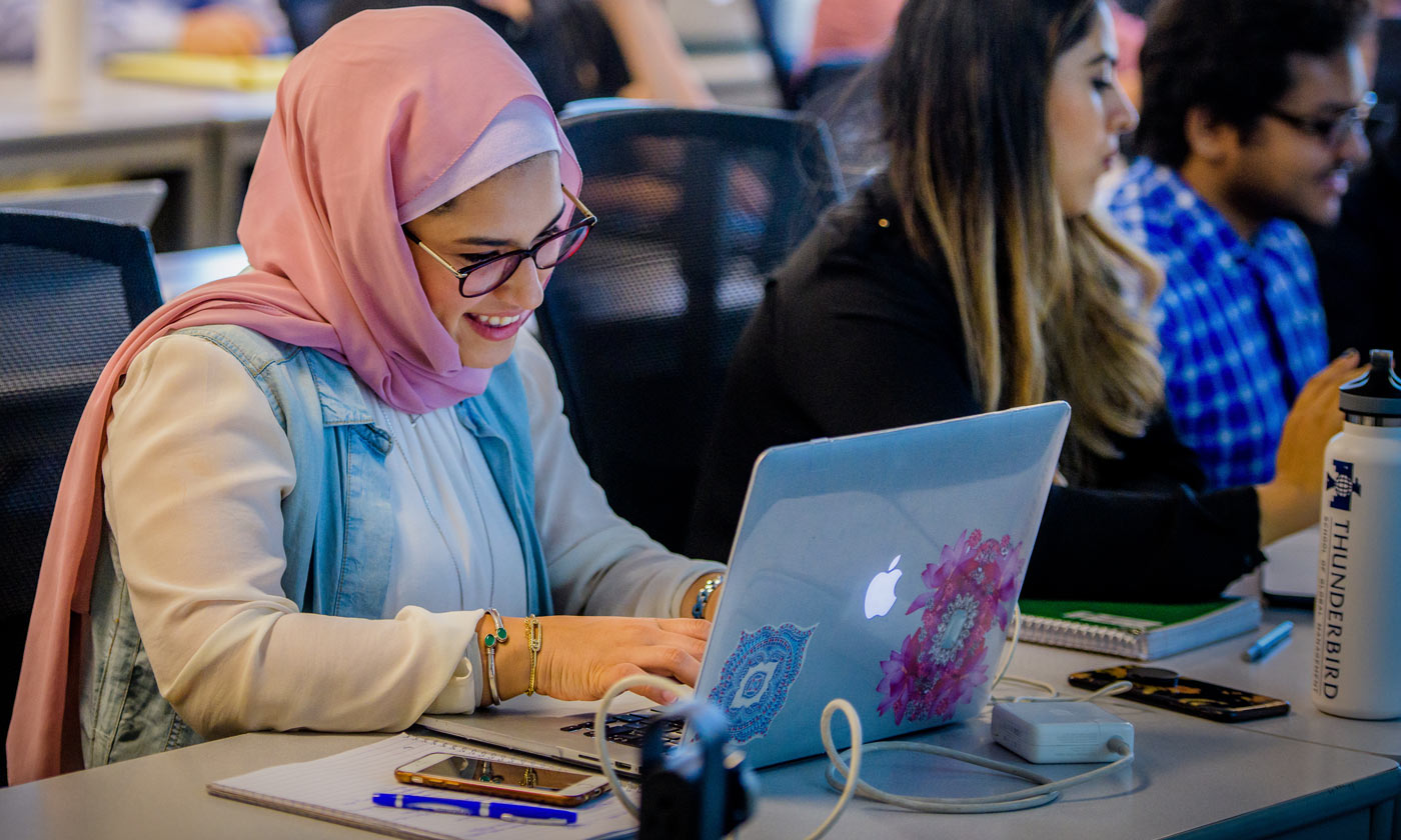 طالبة محجبة تتعلم باستخدام اللابتوب